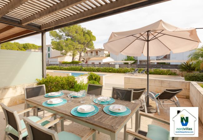 Terrasse mit Tisch, Sonnenliegen und Sonnenschirm in Wohnung B Überdachte Terrasse mit Zugang zum Pool