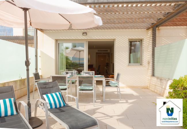 Terrasse mit Sonnenliegen und Sonnenschirmen in La Nau B Terrasse der Wohnung mit Sonnenschirm und Zugang zum Pool
