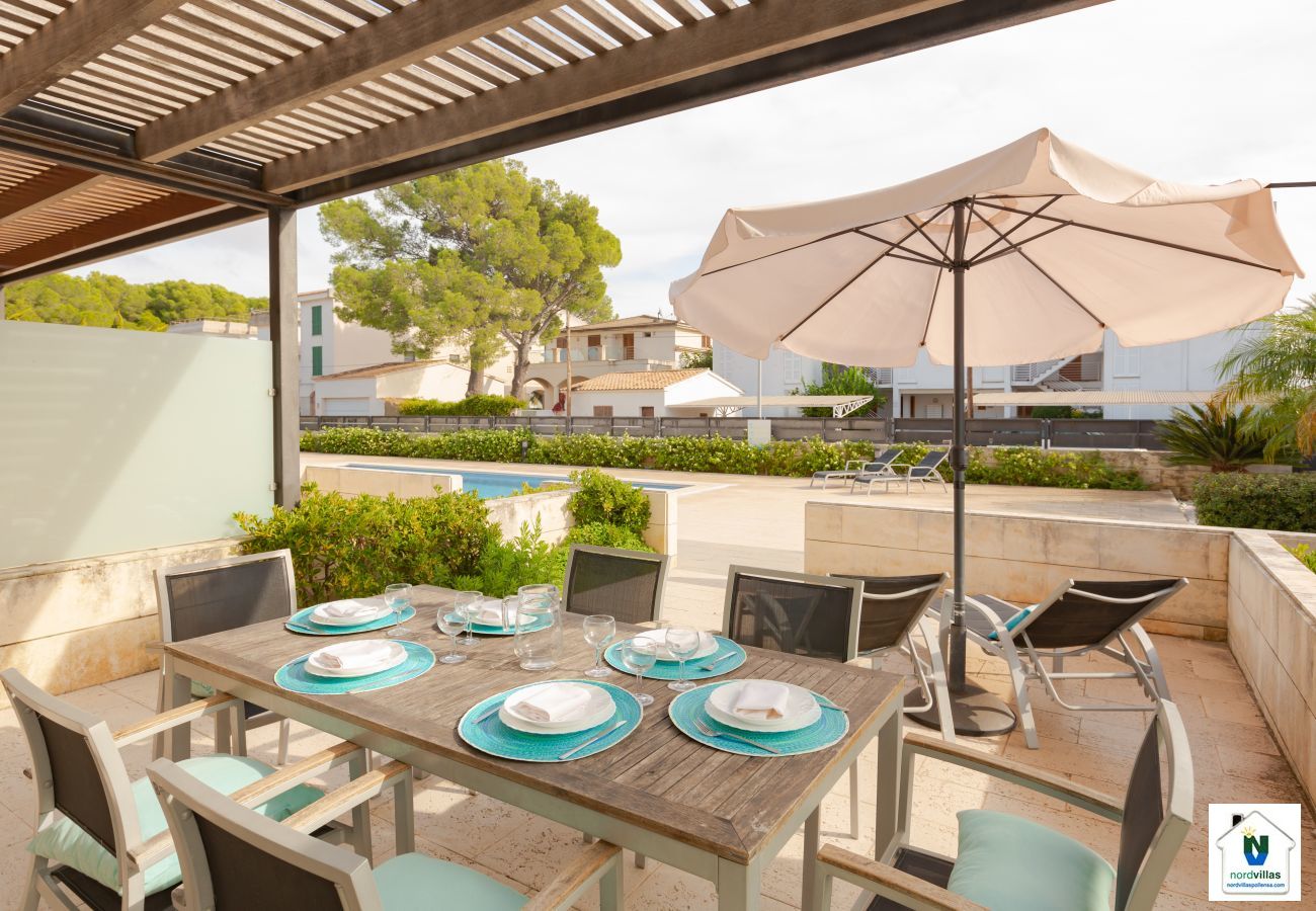 Terrace with table, sun beds and umbrella in apartment B Covered terrace with access to the pool